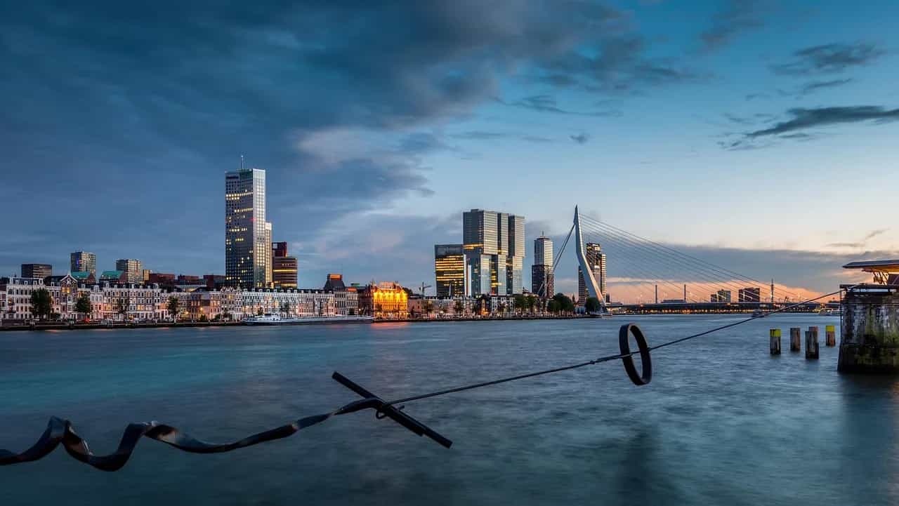 Rotterdam skyline and the Erasmus Bridge at dusk, seen across the Nieuwe Maas.