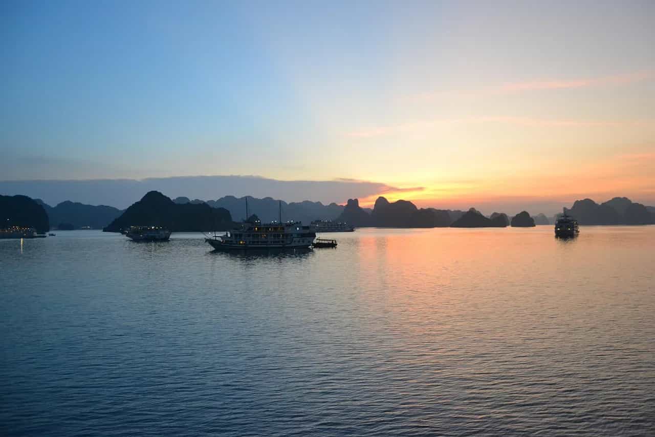 Shkëmbinj gëlqerorë në perëndim, Gjiri Ha Long, Vietnam – anije duke lundruar në ujëra të qeta