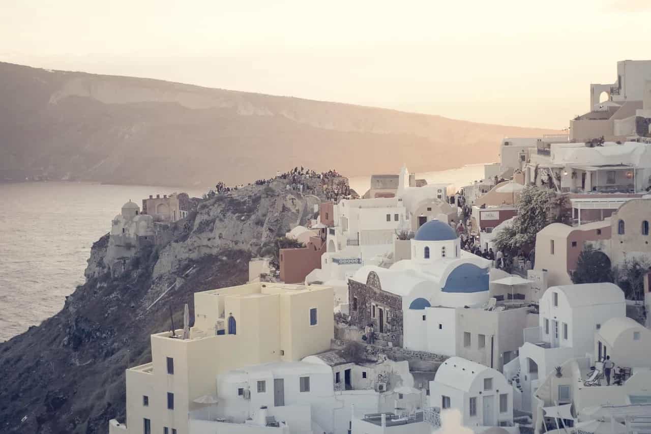 Kishat me kupola blu mbi kraterin, Santorini, Greqi – ora e artë në Oia