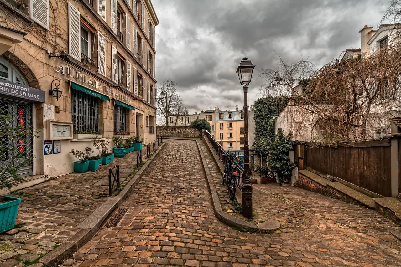 Rrugë me kalldrëm në Montmartre, Paris, Francë – rrugicë e qetë me llambadar dhe fasada të vjetra