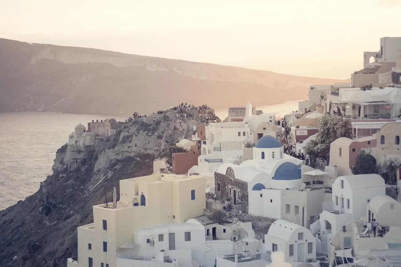 Kishat me kupola blu mbi kraterin, Santorini, Greqi – ora e artë në Oia