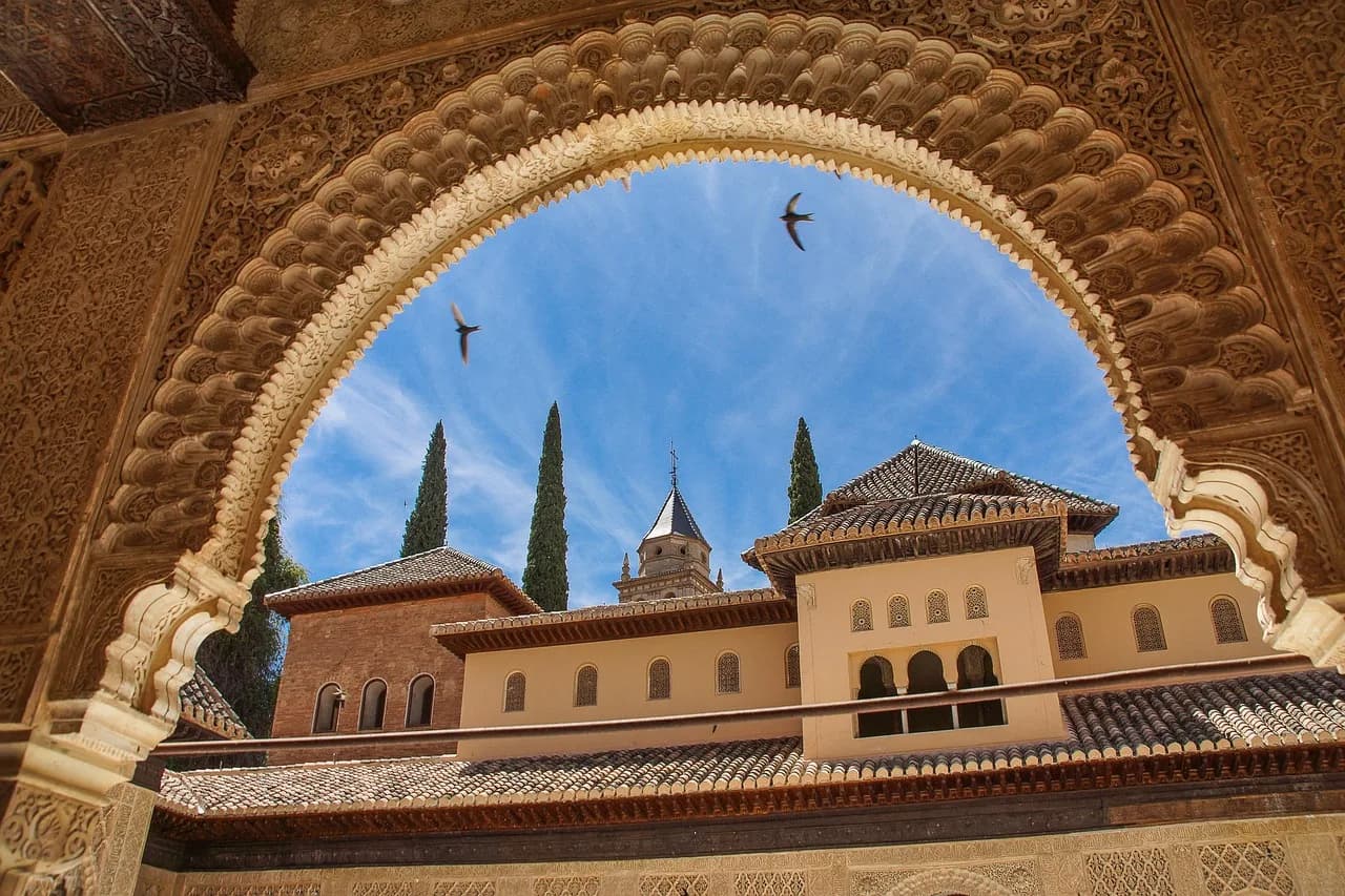 Kullat e pallatit Alhambra, Granada, Andaluzi, Spanjë – arkitekturë maure e kornizuar nga një hark