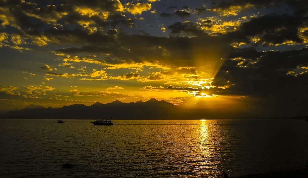 Perëndim dielli mbi gjirin dhe Malet Taurus, Antalya, Turqi – dritë e artë mbi bregdetin mesdhetar