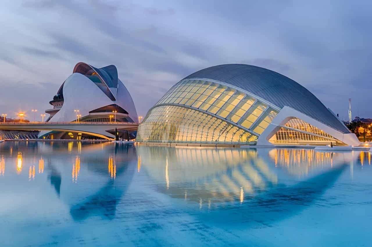 Calatrava's white City of Arts and Sciences reflected in still water at dusk, Valencia.