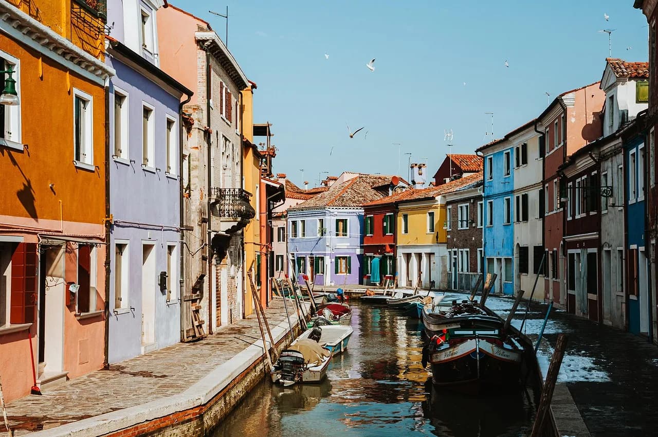 Brightly painted houses along a narrow canal on the island of Burano, in the Venetian lagoon.