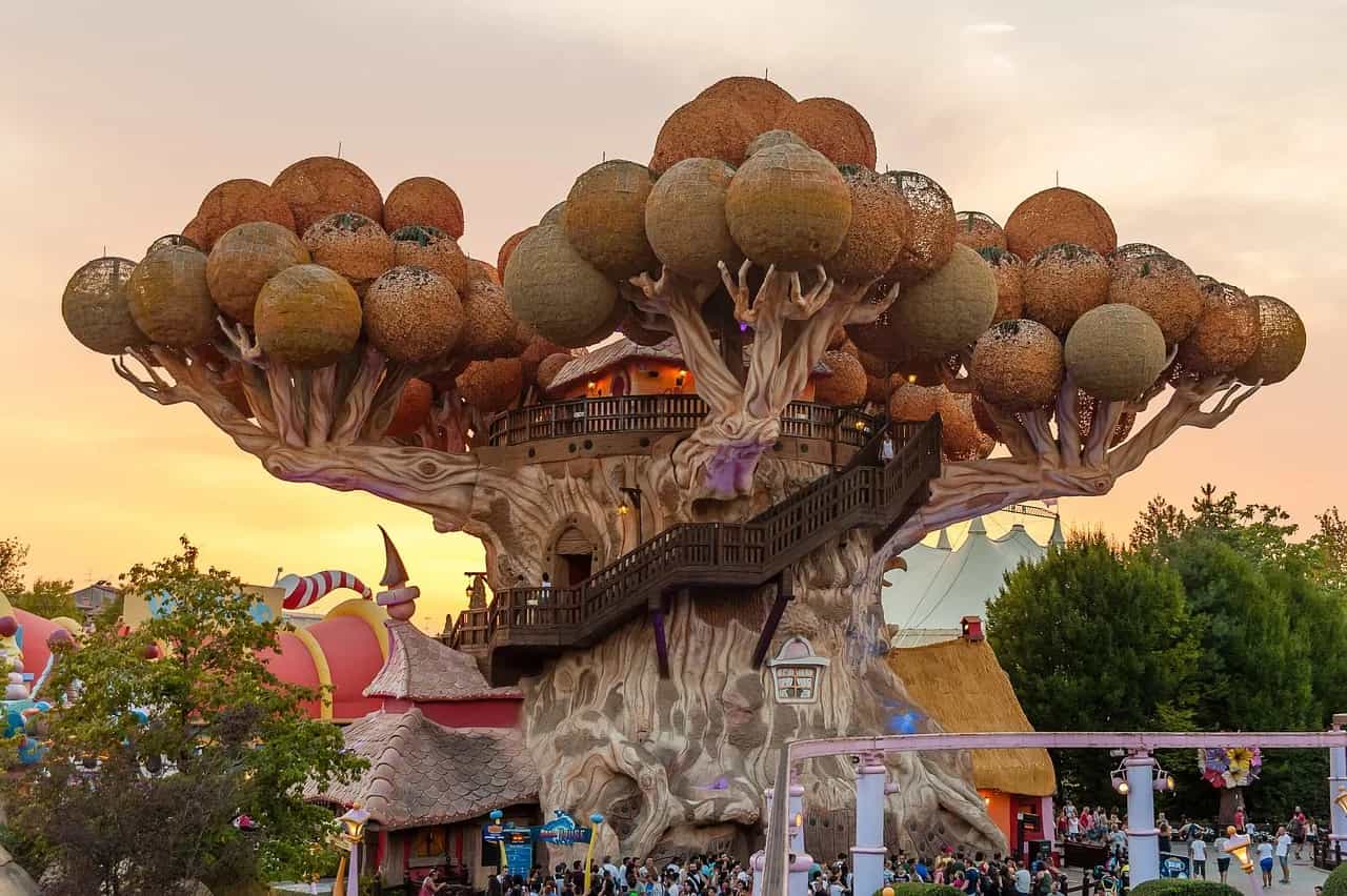 The giant themed tree house at the heart of Gardaland glowing in the light of sunset.