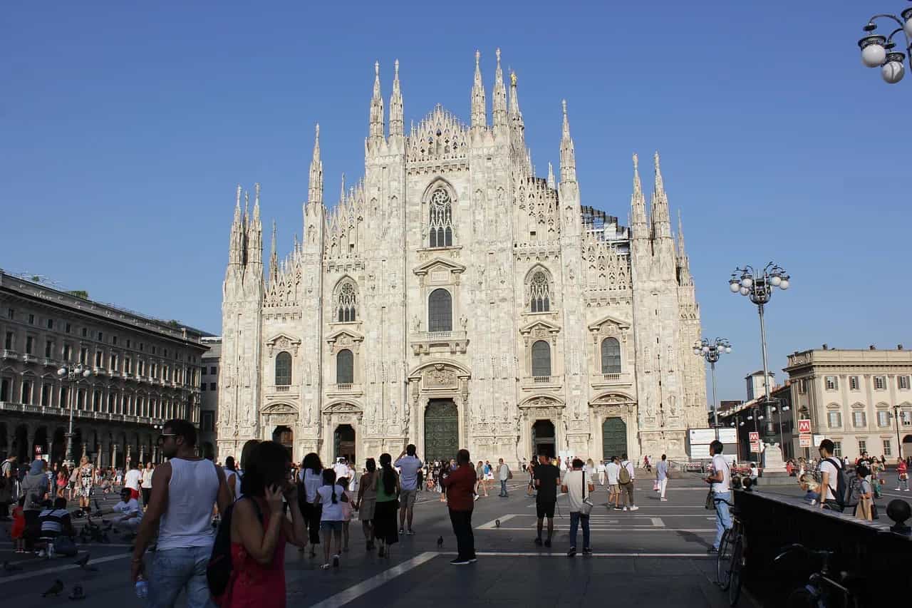 The white marble façade of Milan's Duomo seen from the piazza on a clear day.