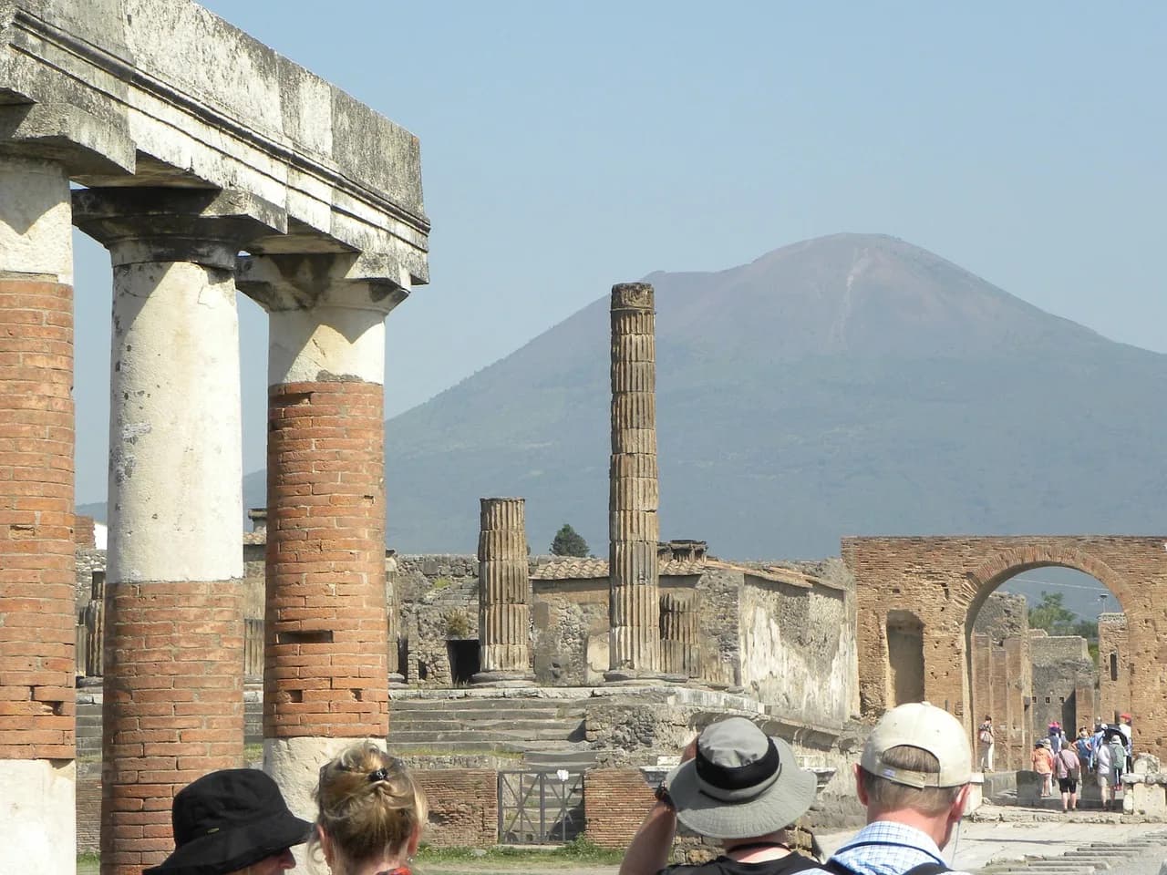Ruined columns of the Forum at Pompeii with Mount Vesuvius rising behind.