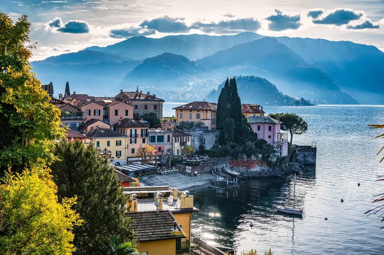 The lakeside village of Varenna on Lake Como, with pastel houses and misty mountains behind.