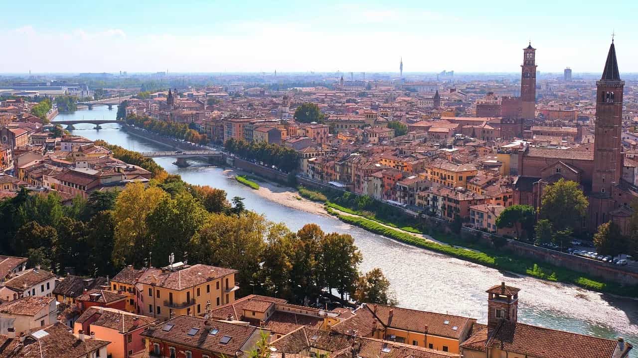 Tetti in cotto e campanili di Verona lungo l'ansa del fiume Adige.